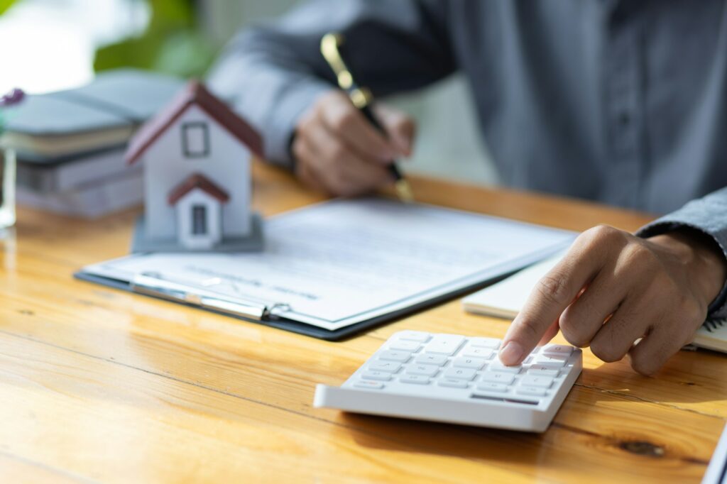 Real Estate Investment Essentials for Beginners | In-depth Guide 3 Business people calculating interest, taxes and profits to invest in real estate and home buying.